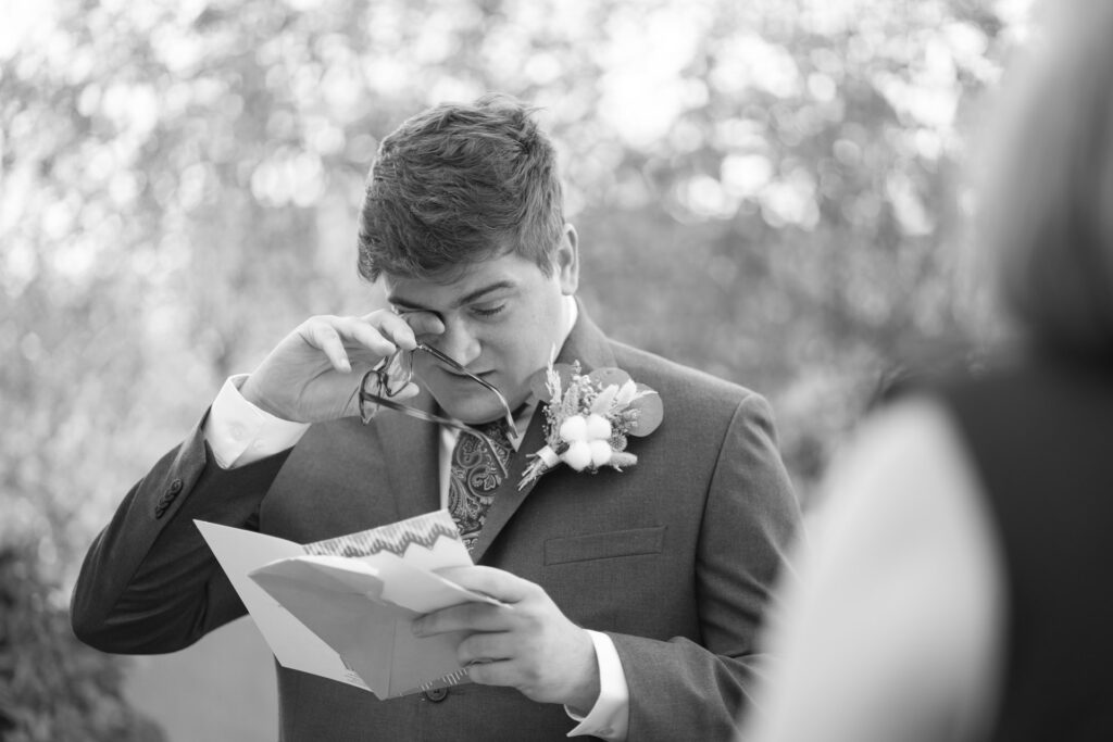 Emotional moment of a groom reading handwritten vows at a Sedona micro wedding.